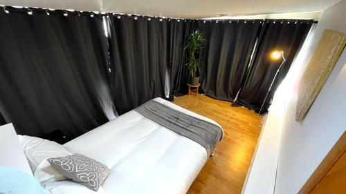 爱丁堡Elegant 2 Bedroom Chalet的卧室配有黑色窗帘和白色的床。