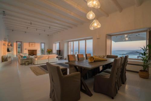 米克诺斯城Alia Luxury Villa Mykonos的客厅配有餐桌和椅子