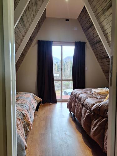门多萨Cabañas Alpinas的一间卧室设有两张床和大窗户