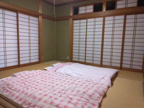 饭田市BANRYU 萬龍 バンリュウ的一间设有床铺的卧室,位于带窗户的房间内
