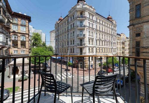 基辅Sophia Hotel Kyiv的阳台配有椅子,街道上拥有建筑