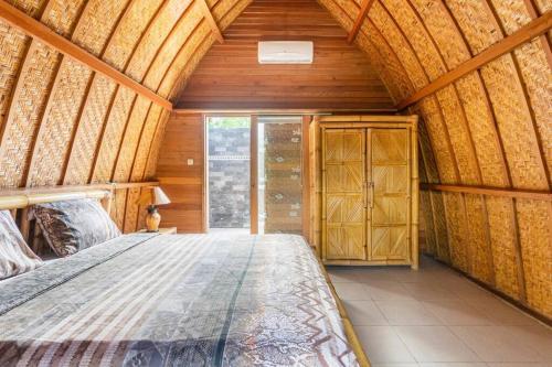 吉利阿尔达梅斯朗邦假日公园的木制客房内的一间卧室,配有一张床