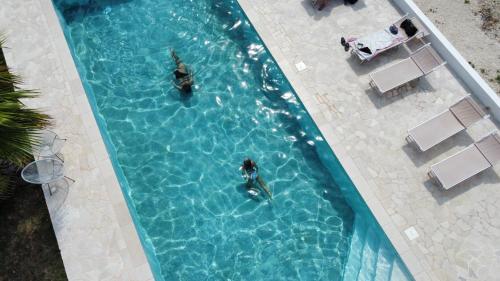GiuggianelloMasseria Petrusella的两人在游泳池游泳的顶部景色
