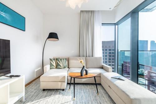 迪拜Welcome Home Apartments - VIDA Marina - Full Marina view - High Floor的客厅配有沙发和桌子