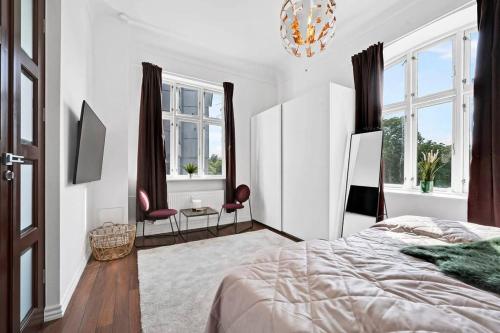 奥胡斯The Modern Breakaway in Aarhus的白色卧室配有一张床和一个吊灯