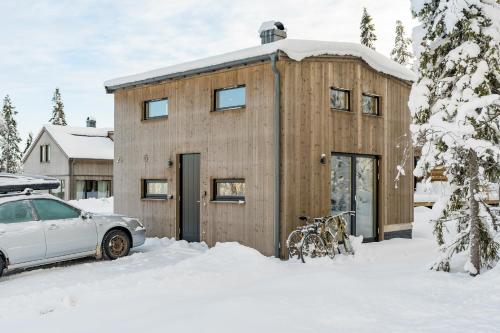 萨伦Mysig liten stuga perfekt för par eller liten familj的木屋,有车停在雪中