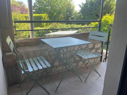 香槟沙隆La Bulle的阳台配有一张桌子和两把椅子