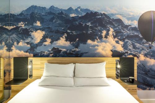 利兹诺富特利兹中心酒店的一间卧室配有一张带山壁画的床