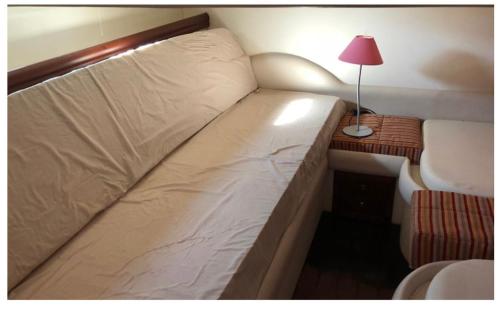 滨海圣芒德里耶Nuit à Bord "SOGNO"的一张大床,位于一个小房间里,配有台灯