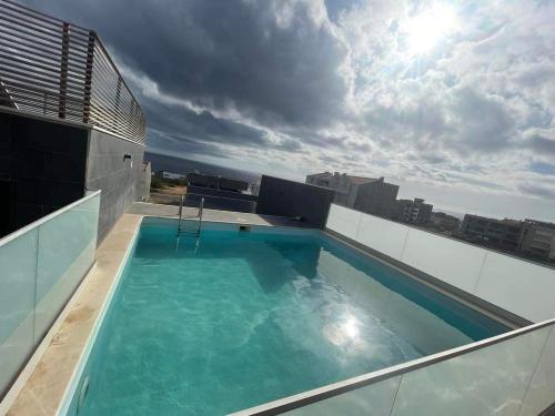 普拉亚Kriol Guest House的建筑物屋顶上的游泳池