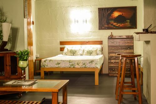 Quatre SoeursThe Green Shack的一间卧室配有床、桌子和凳子