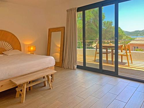 博尼法乔马奥拉别墅酒店的一间卧室配有一张床,阳台配有桌子