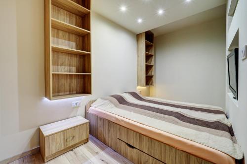 塞格德Egyetem Apartman的一间带一张床和木制橱柜的小卧室