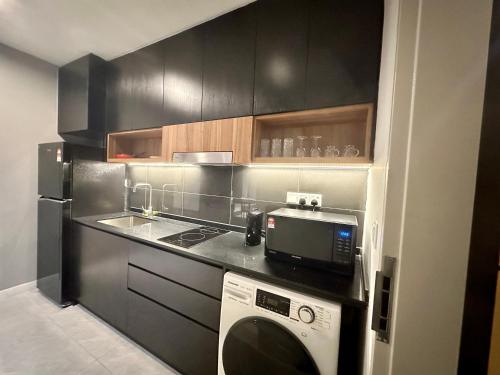 吉隆坡Crystal Suites at Axon Residence near Pavilion的厨房配有洗衣机和微波炉。