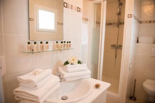 莱萨布勒-多洛讷Oasis Les Jardins des Sables d'Olonne的浴室配有水槽、淋浴和毛巾