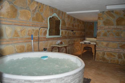 科尔多瓦Apartamentos El Aljibe Relax Tourist Cordoba的石墙客房内的浴缸
