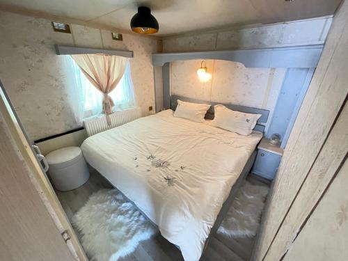 瓦莱德拉加努鲁伊Riverside Caravan的一间小卧室,配有一张白色的床和窗户