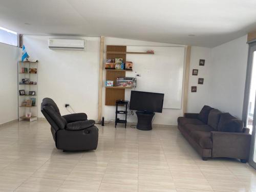 库库塔Hermosa Casa Campestre的客厅配有2张沙发和1台平面电视