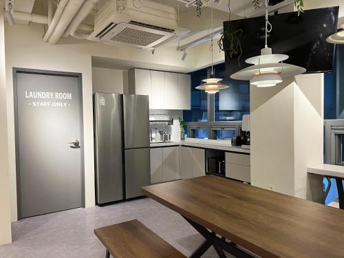 首尔Seoul Cube Jongro的厨房配有木桌和冰箱。