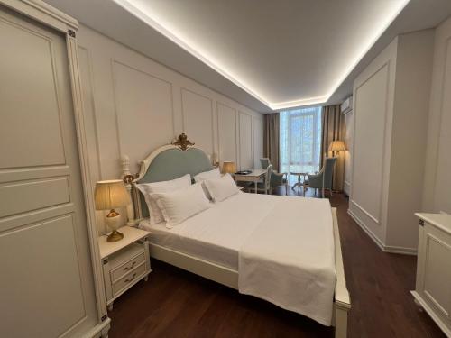 都拉斯SOL INVICTUS Boutique Hotel Durres Albania的卧室配有一张白色大床和一张书桌