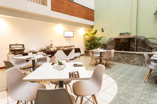 San PedroApartotel Tairona的一间带桌椅和壁炉的餐厅
