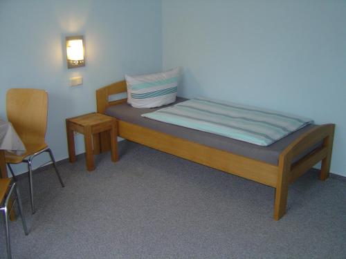 穆特尔斯塔特露丝旅馆的一间小卧室,配有一张床和一把椅子