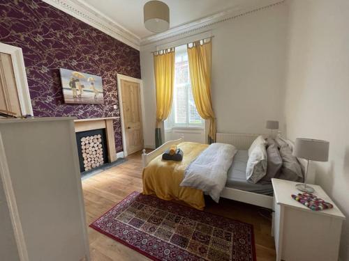 格拉斯哥Stunning West End Flat!的一间卧室配有一张床、一张桌子和一个窗户。