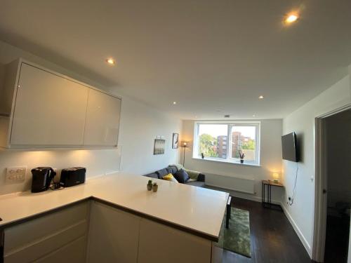 萨顿Lovely 1 BR flat in Sutton NH116的一间带白色台面的厨房和一间客厅