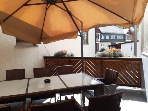 克林根塔尔Hotel zur Post的阳台配有桌椅和遮阳伞