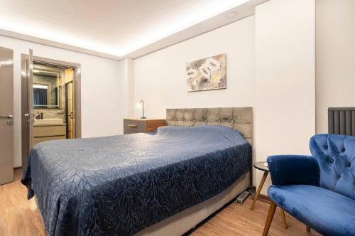 伊斯坦布尔Luxury apartment in the heart of Nisantasi的一间卧室配有一张床和一张蓝色椅子