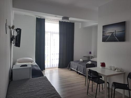 格丁尼亚Figaro Apartaments的一间卧室配有一张床和一张桌子及椅子