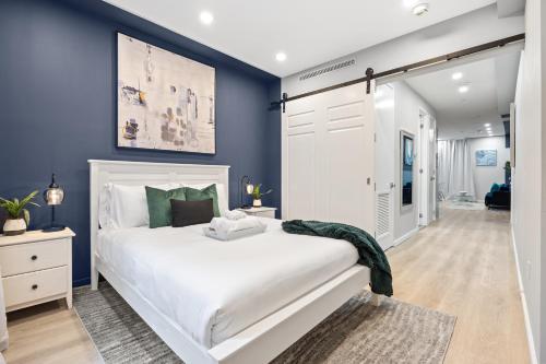 纽约SWJ G - Save on 2Day or more Stays 25min to Times Sq的卧室配有白色的床和蓝色的墙壁