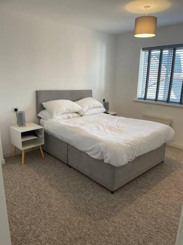 Redhill5 Holborn Spacious Home的卧室配有一张带白色床单和枕头的大床。