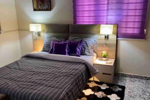 MakurduPeniel Place的一间卧室配有一张大床和紫色窗帘