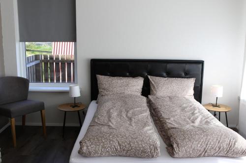 雷克霍特Grímsstaðir holiday home - Family friendly的一间卧室配有一张带黑色床头板和枕头的床。
