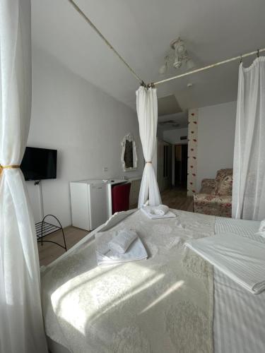 阿尔巴尤利亚Hotel Prestige的卧室配有一张带白色窗帘的大床