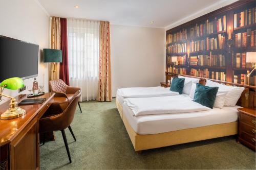 科赫姆哲迈尼尔酒店的酒店客房配有一张床、一张书桌和一台电脑
