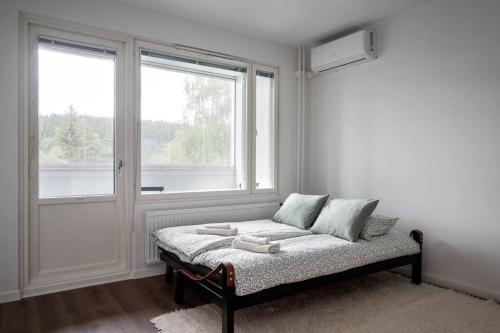 库奥皮奥Moderni ja tilava kolmio + sauna的白色的房间,窗户前设有一张床