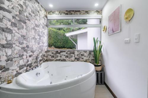 Verbena NorteHouse of Turri Suite, Views & Jacuzzi的带窗户的浴室内的白色浴缸
