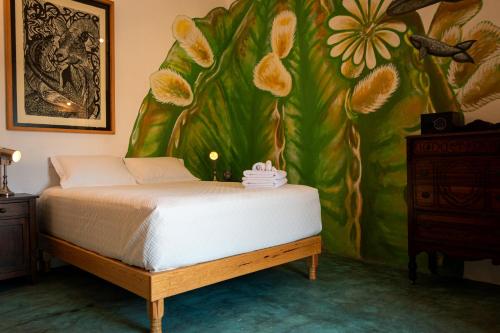 拉巴斯Casa Bahia的卧室配有一张床,墙上挂有绘画作品