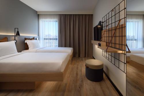 里斯本Moxy Lisboa Oriente的酒店客房设有两张床和窗户。