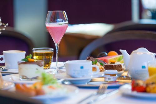 利托米什尔阿普朗斯酒店的坐在桌子上一边品尝葡萄酒,一边享用食物