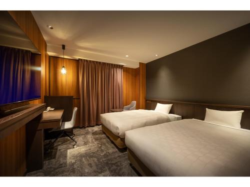 三沢市Misawa City Hotel - Vacation STAY 81776v的酒店客房配有两张床和一张书桌