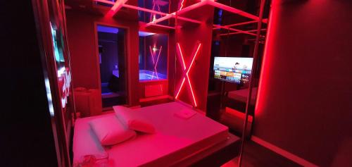 贝洛奥里藏特莫泰幻想3情趣酒店（仅限成人）的红色的房间配有沙发和电视