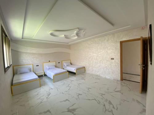 阿加迪尔Villa avec piscine à Agadir的客房铺有大理石地板,配有两张床。