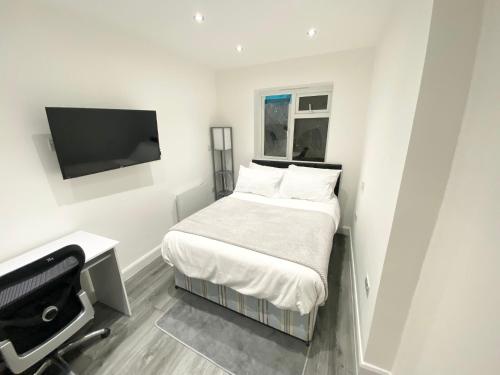 清福德London Studio的一间小卧室,配有一张床和一台平面电视