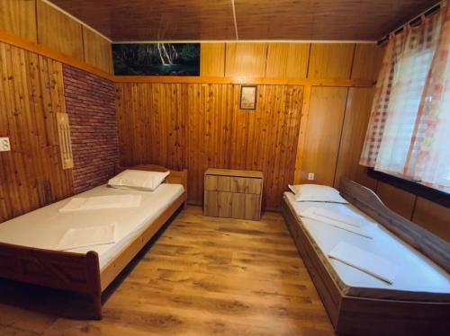 卡赞勒克Къщи за гости Армагански път的木墙客房的两张床