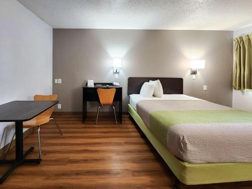 贝敦休斯敦东贝敦6号汽车旅馆的配有一张床和一张书桌的酒店客房