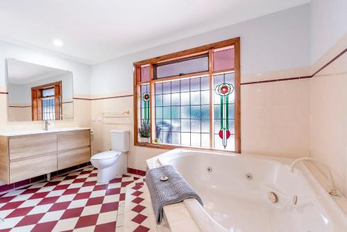 塔南达Welcoming Ambiant 3BR Abode的带浴缸、卫生间和窗户的浴室