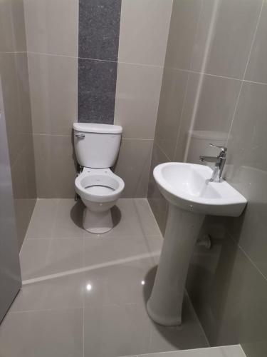 普卡尔帕Hotel JK的白色的浴室设有卫生间和水槽。